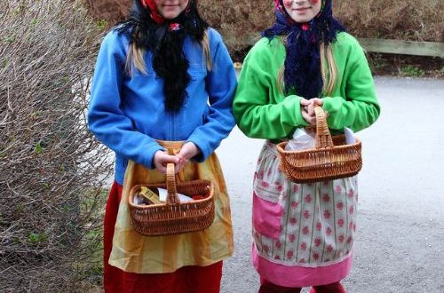 twee zweedse paasheksen kinderen die langs de deuren gaan met een mandje