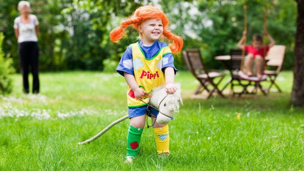 een als pippi verkleed kind met een speelgoedpaard